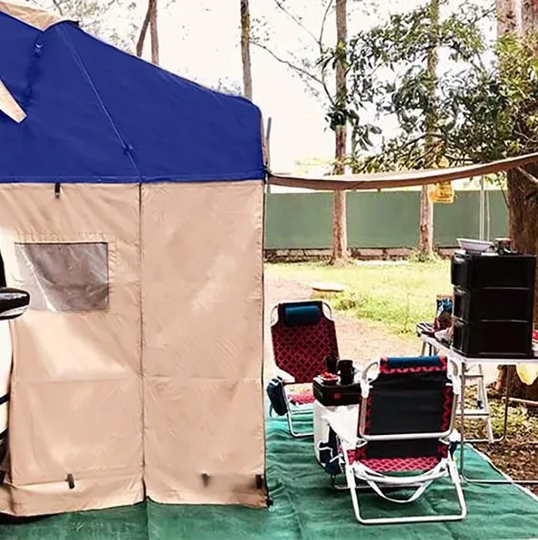 Barraca de teto Top Camp aberta, com o anexo de lona e cadeiras de camping ao lado do carro