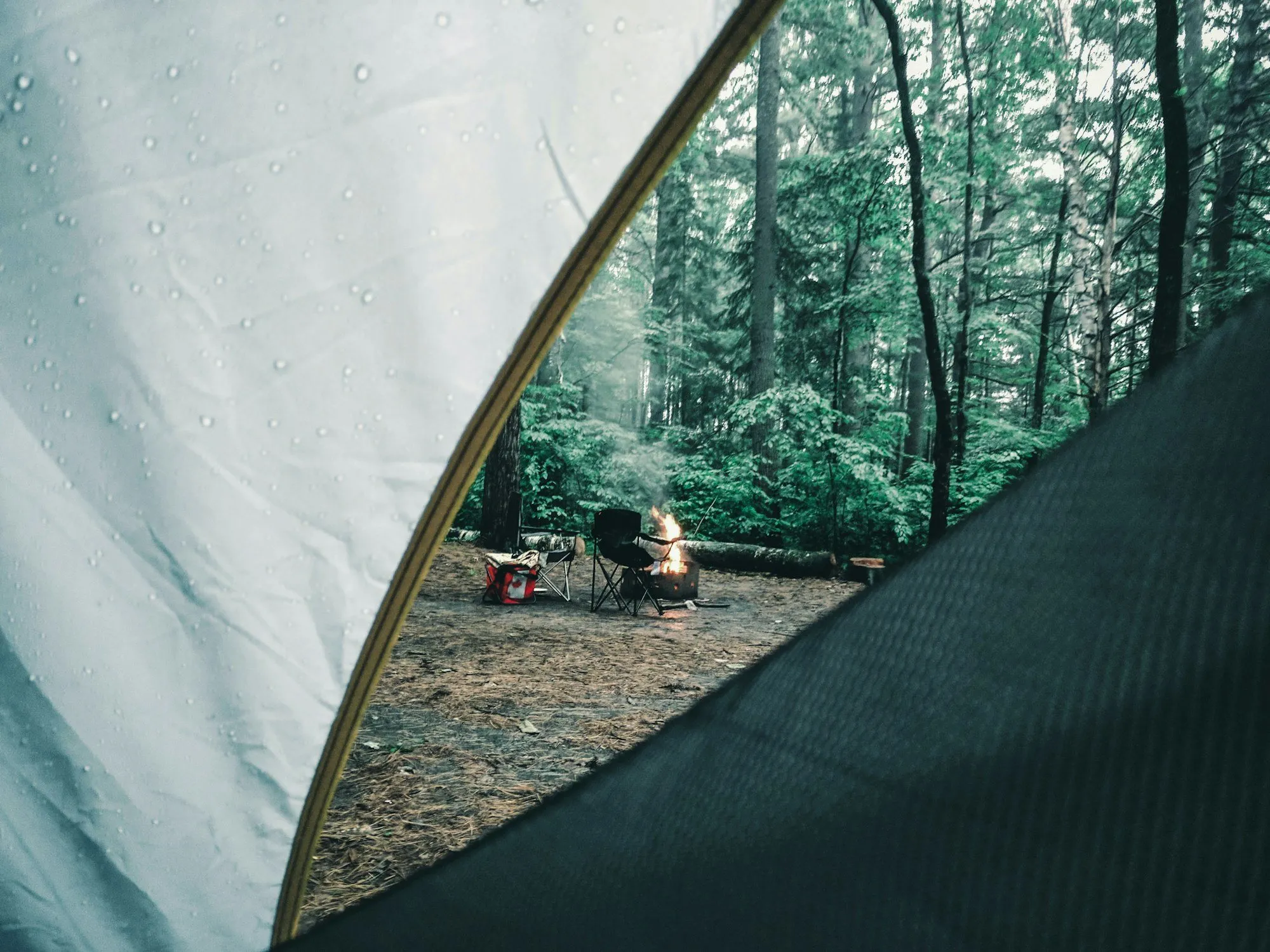 Pessoa sentada em um banco de madeira em área de camping